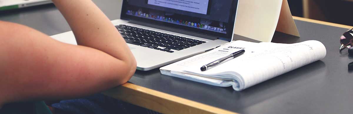 Student working at a laptop in school library